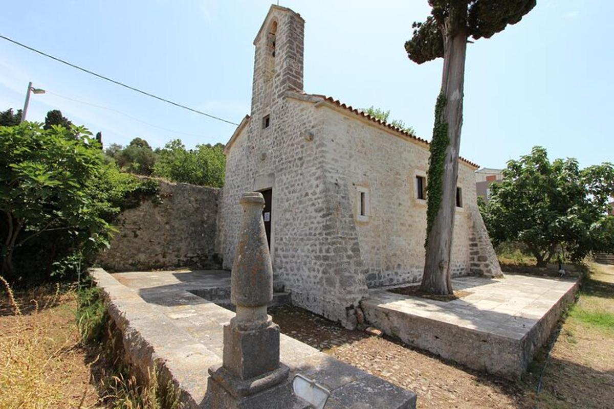 Un antiguo edificio de piedra con un árbol delante.