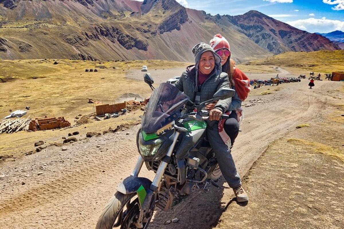 una donna e un bambino in sella a una motocicletta su una strada sterrata