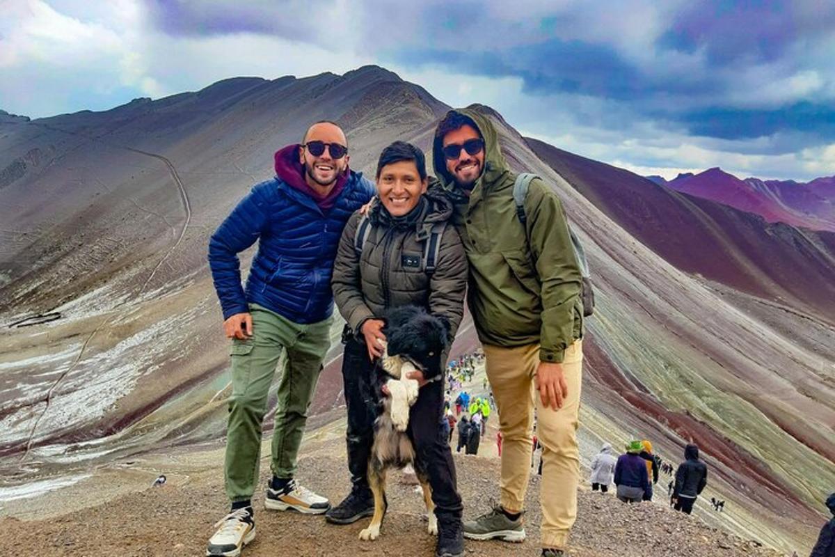 un gruppo di tre persone e un cane su una montagna