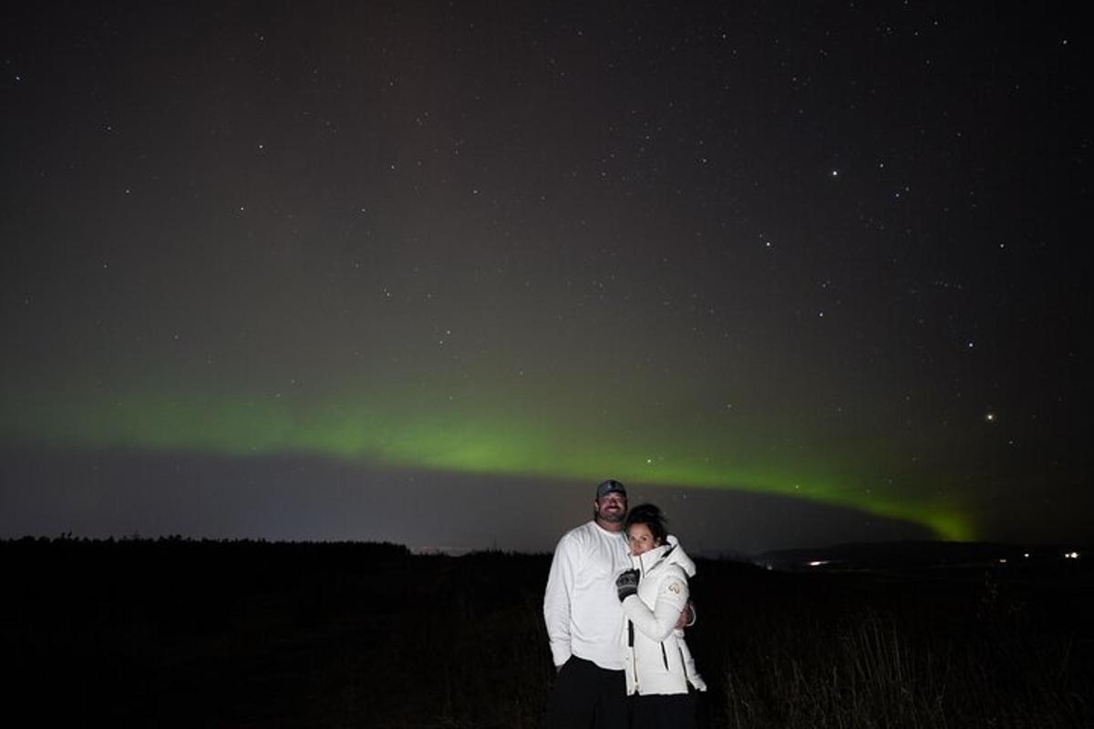 un home i una dona dempeus sota l'aurora boreal