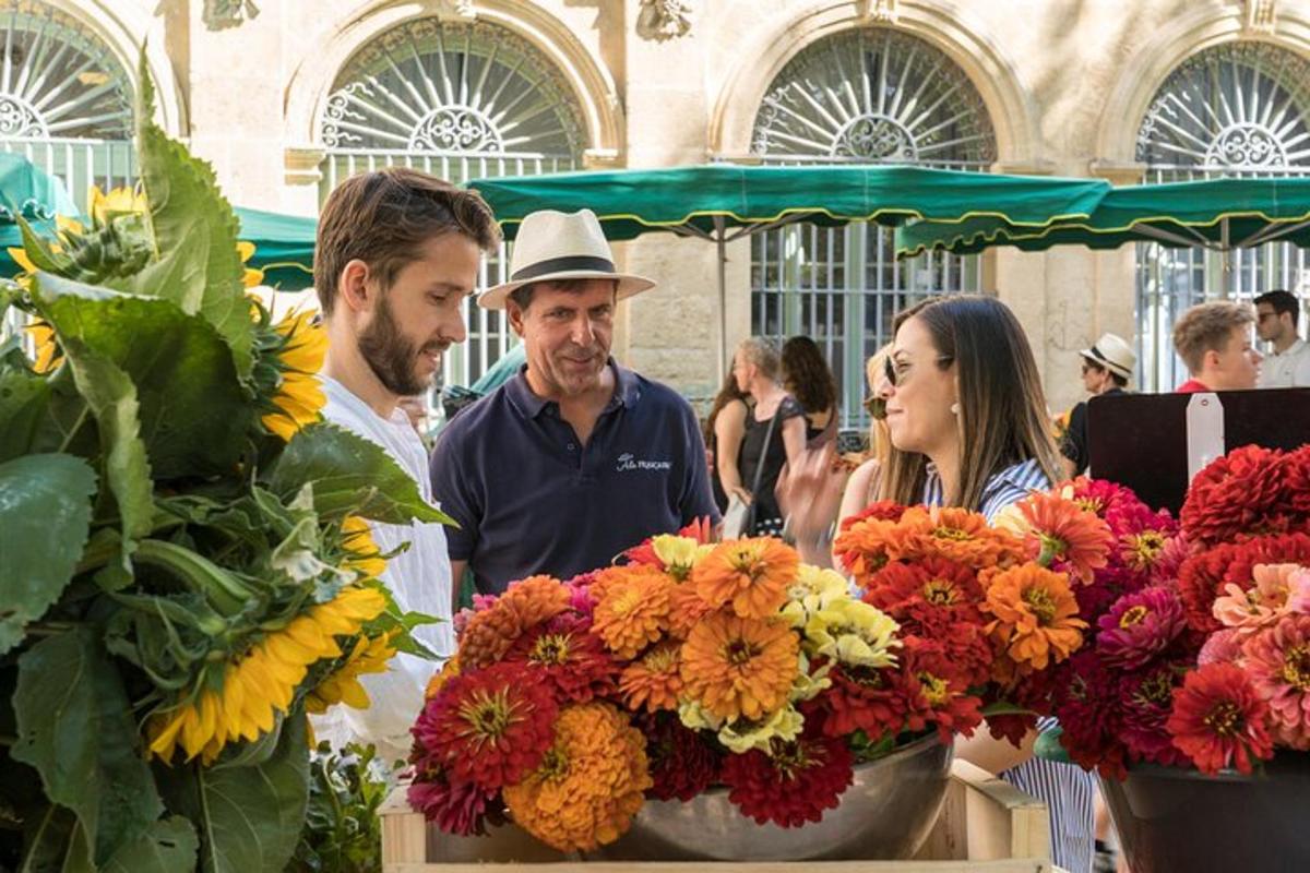 un gruppo di persone che guardano i fiori in un mercato