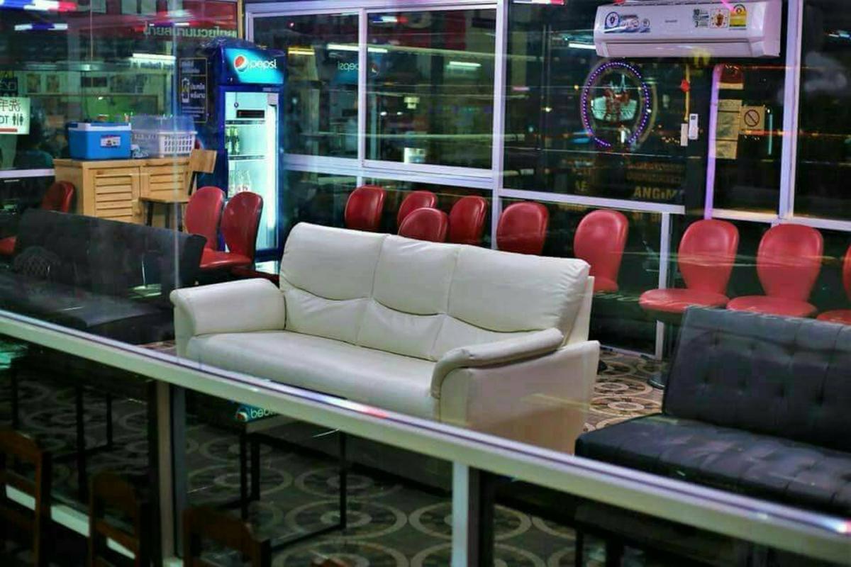a waiting room with a couch and red chairs