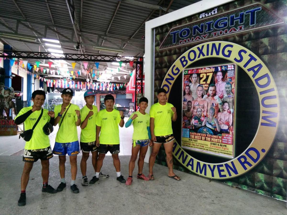 a group of people in yellow shirts standing next to a sign