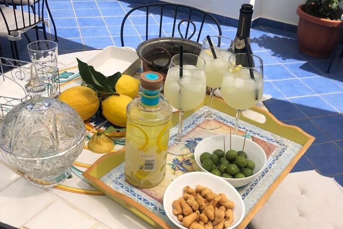 una taula amb gots de llimonada i un bol de fruita
