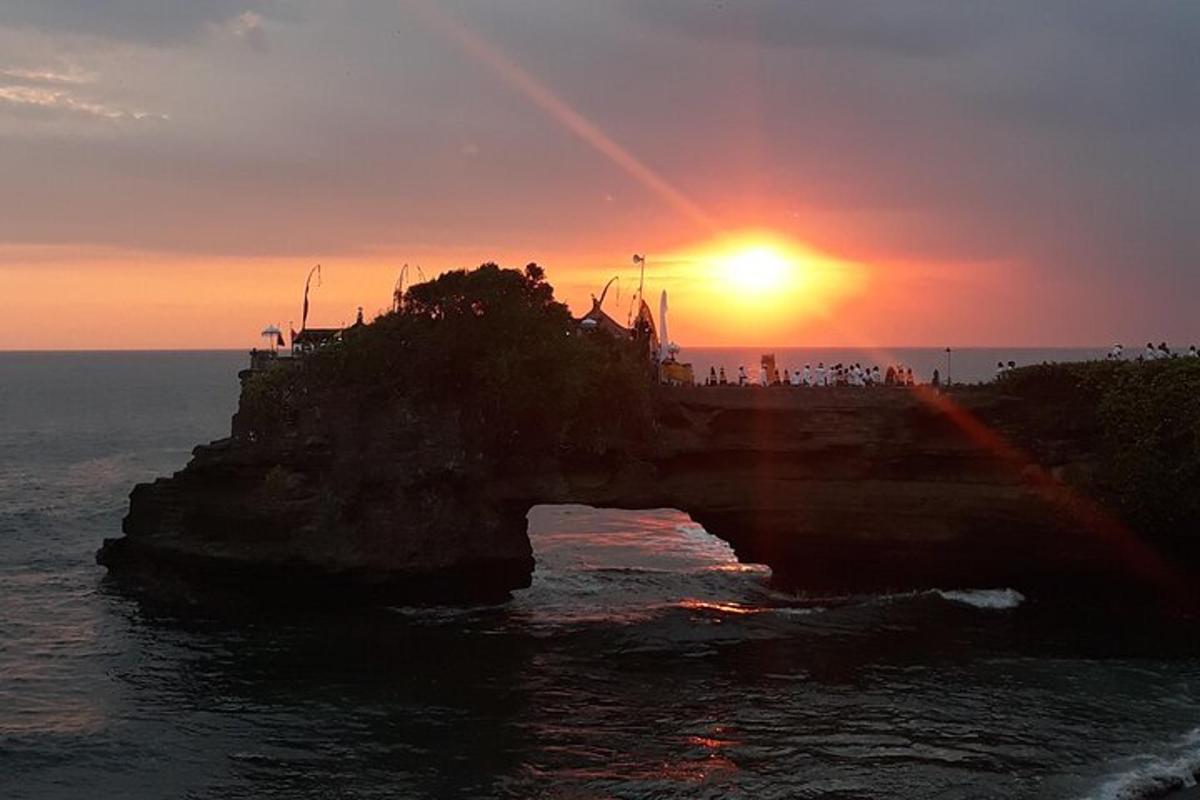 most přes vodu se sluncem zapadajícím nad oceánem