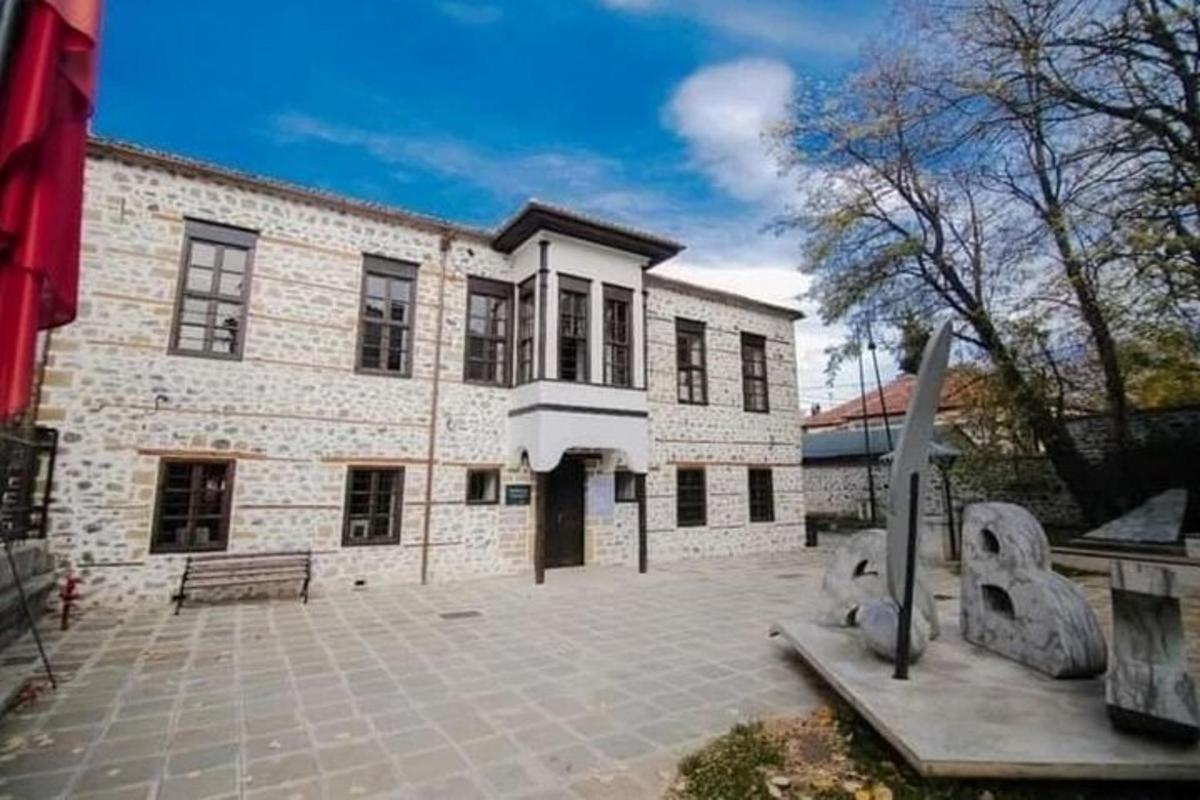 ένα μεγάλο κτίριο από τούβλα με ένα άγαλμα μπροστά του