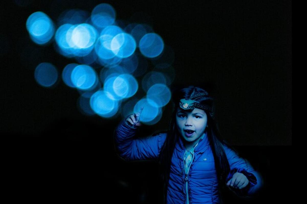 una ragazza tiene in mano un mazzo di luci blu