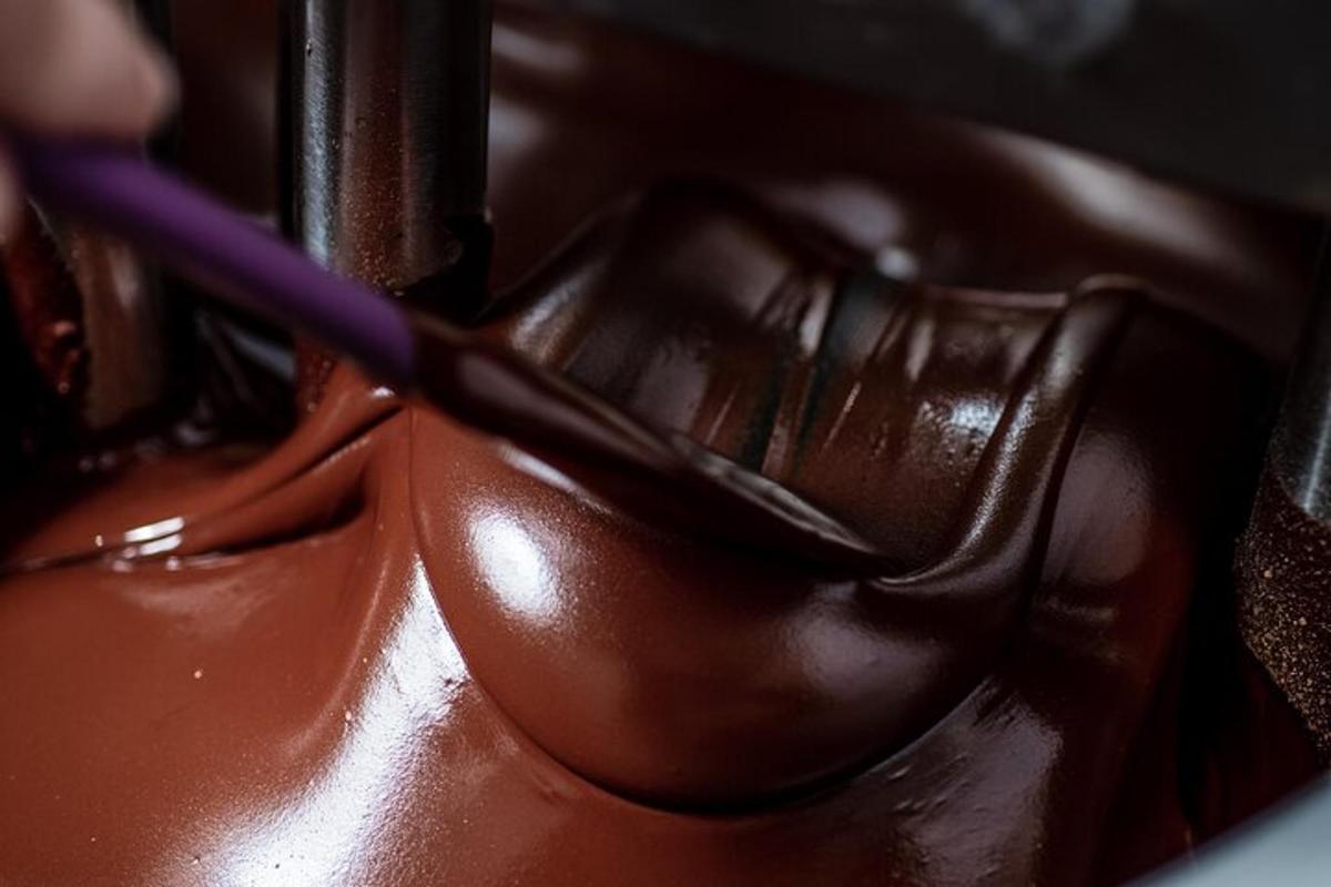 uma pessoa cortando um pedaço de chocolate com uma escova de dentes