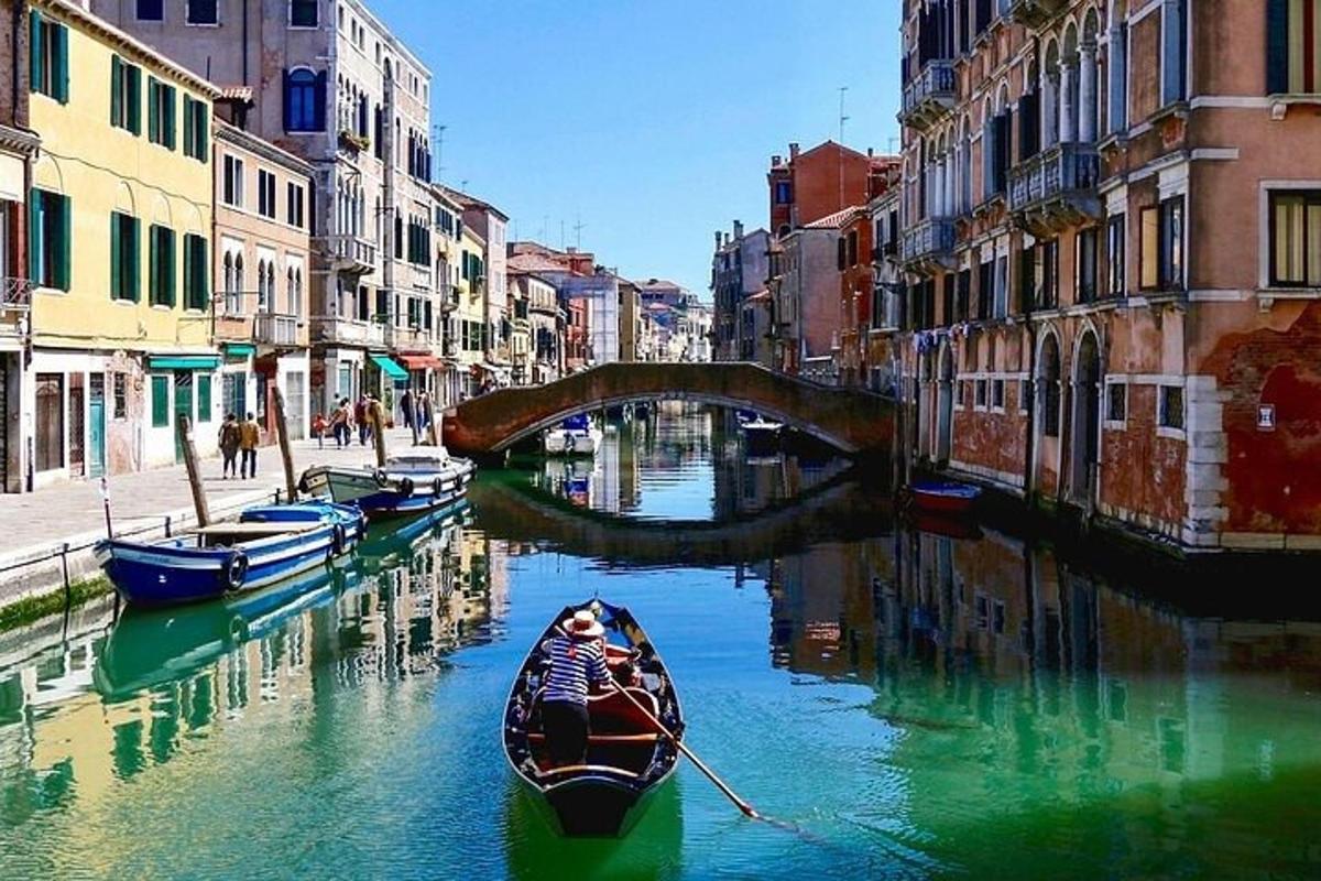 una barca in un canale con un ponte e degli edifici