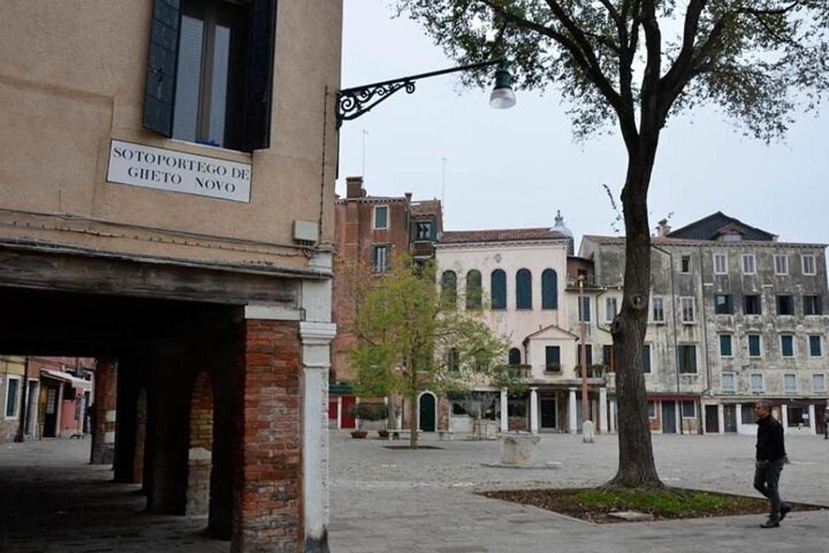 un uomo che cammina lungo una strada accanto a un edificio