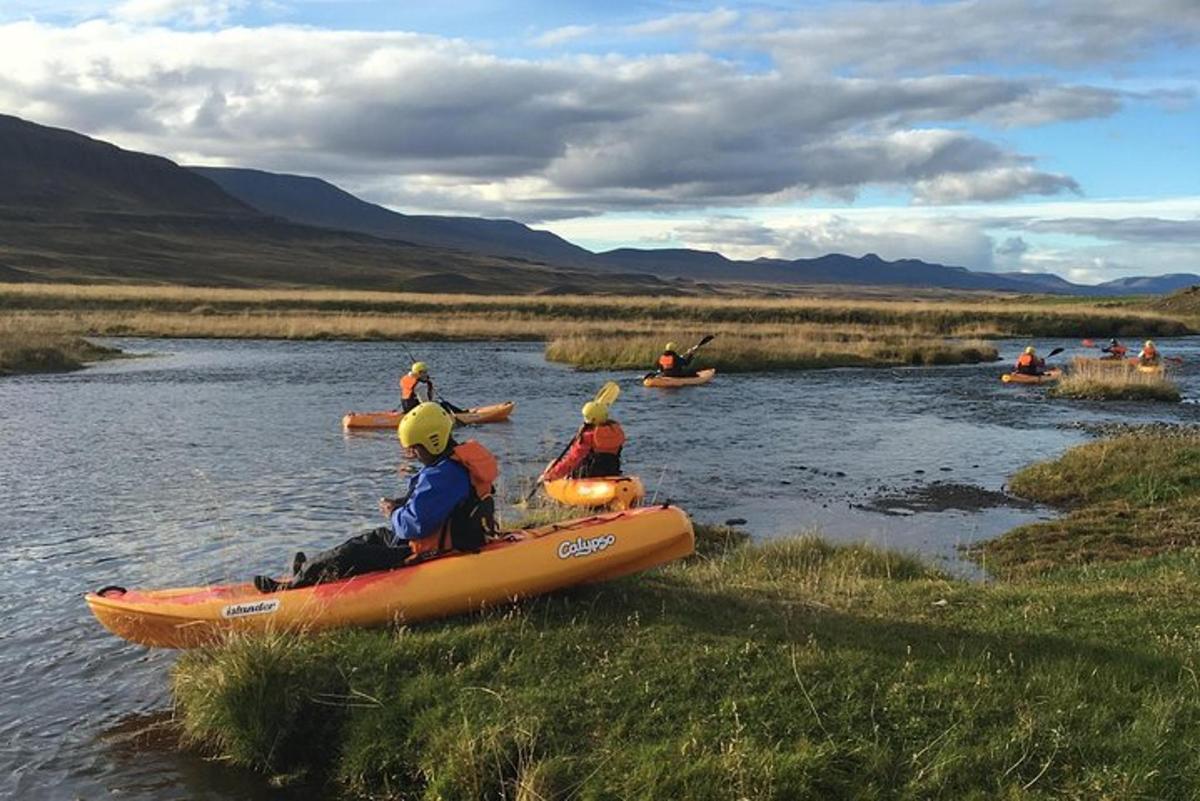 eine Gruppe von Menschen in Kajaks auf einem Fluss