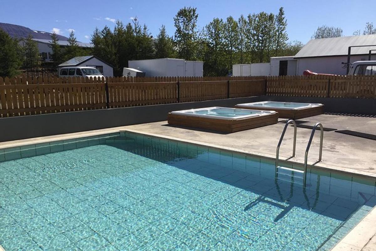 ein Swimmingpool mit zwei Tabletts in einem Hinterhof
