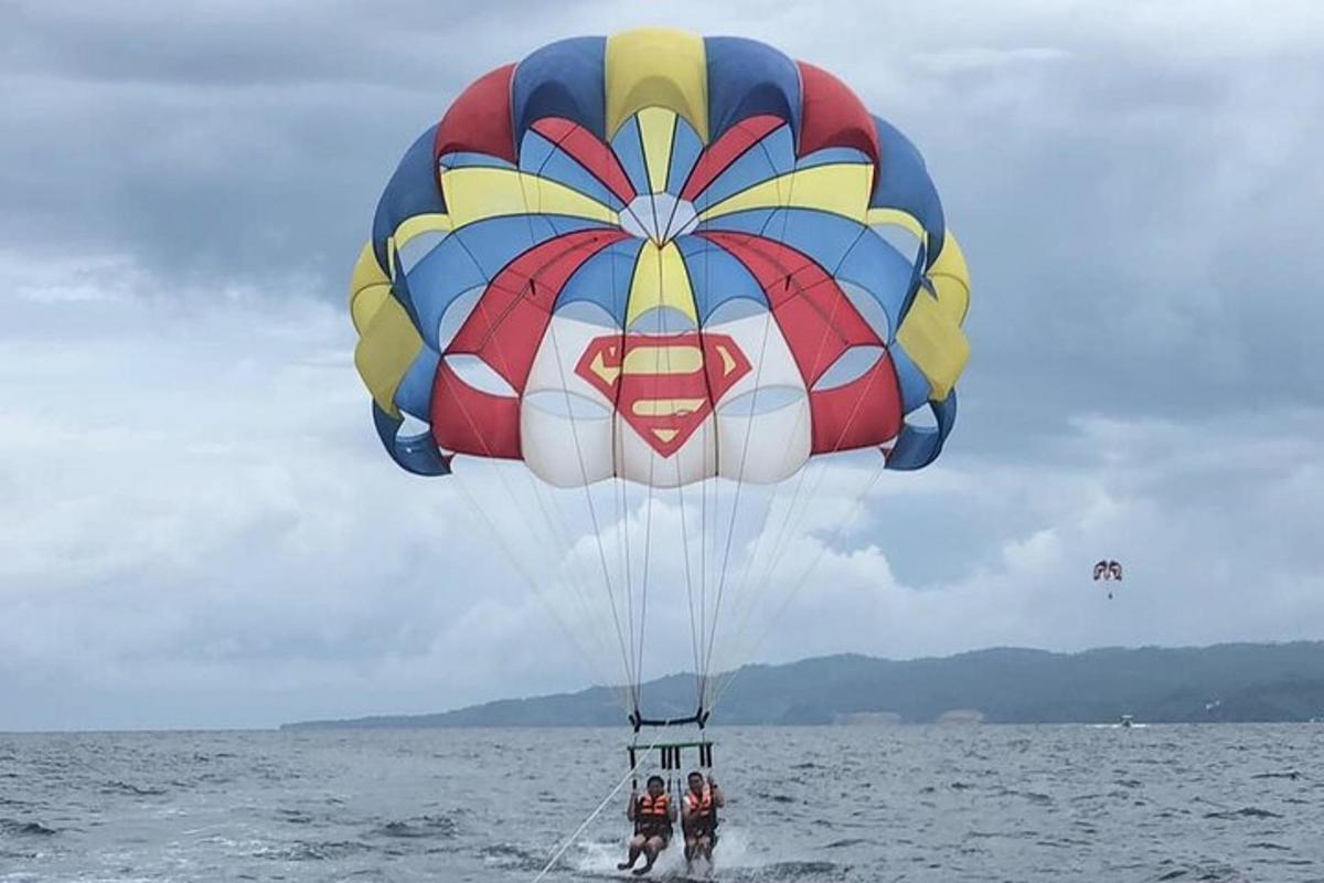 two people flying a large parachute in the water