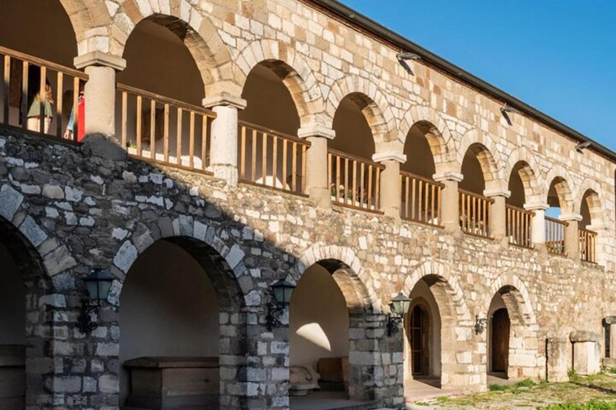 ένα μεγάλο πέτρινο κτίριο με καμάρες και μπαλκόνι