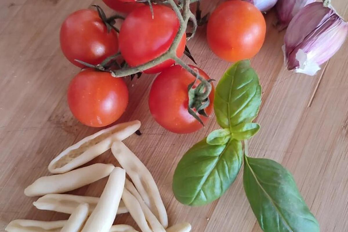 um monte de tomates e outros vegetais em uma mesa