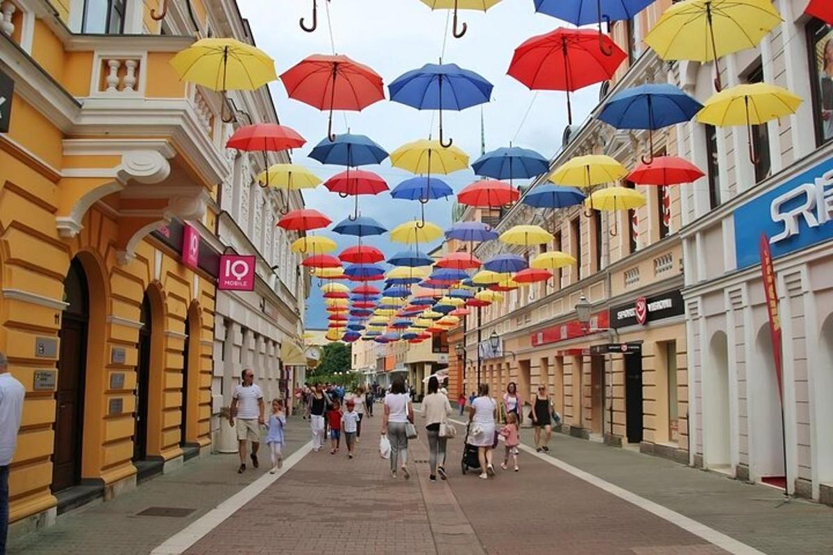a group of people walking down a street under umbrellas