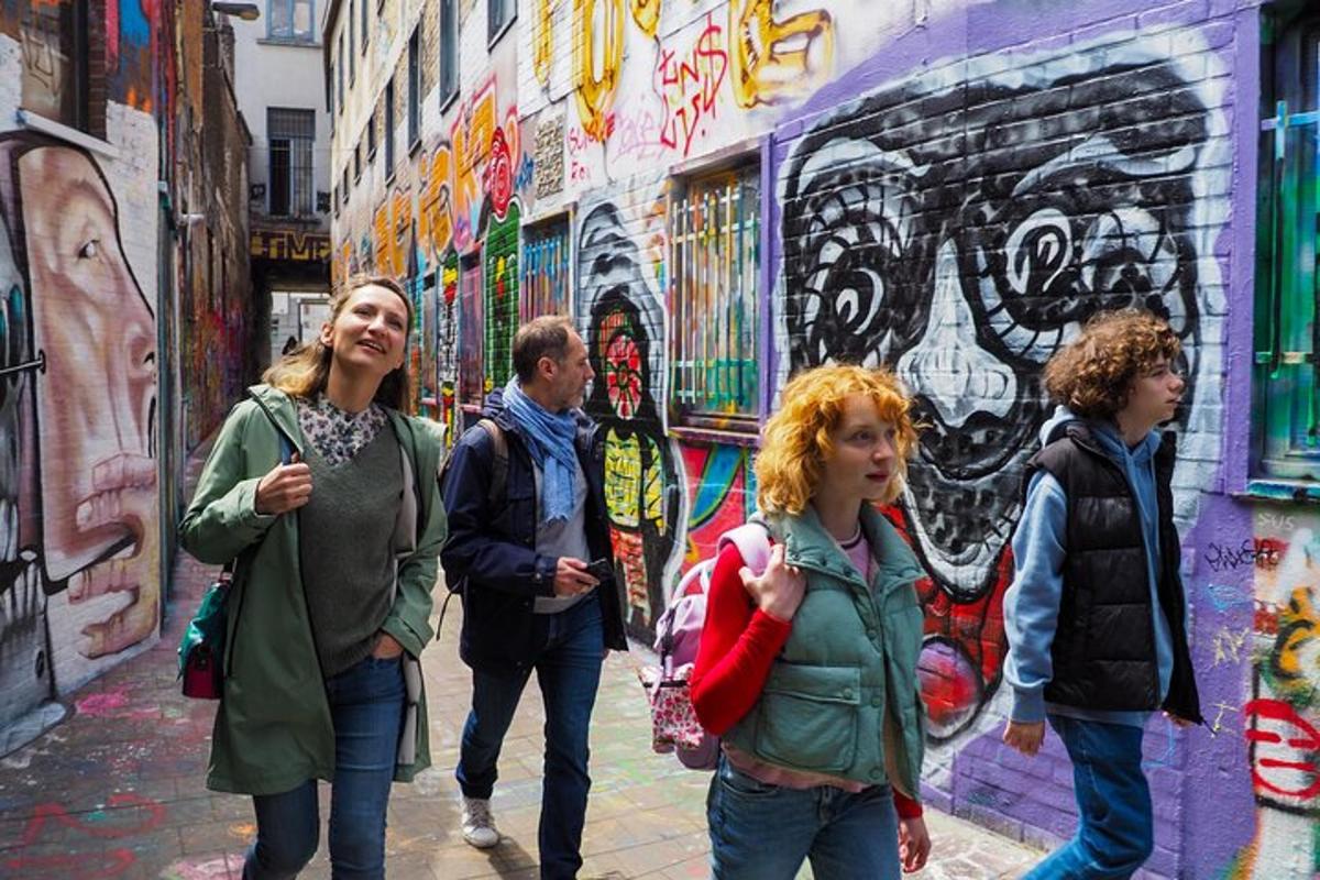 un gruppo di persone che camminano davanti a un muro con graffiti