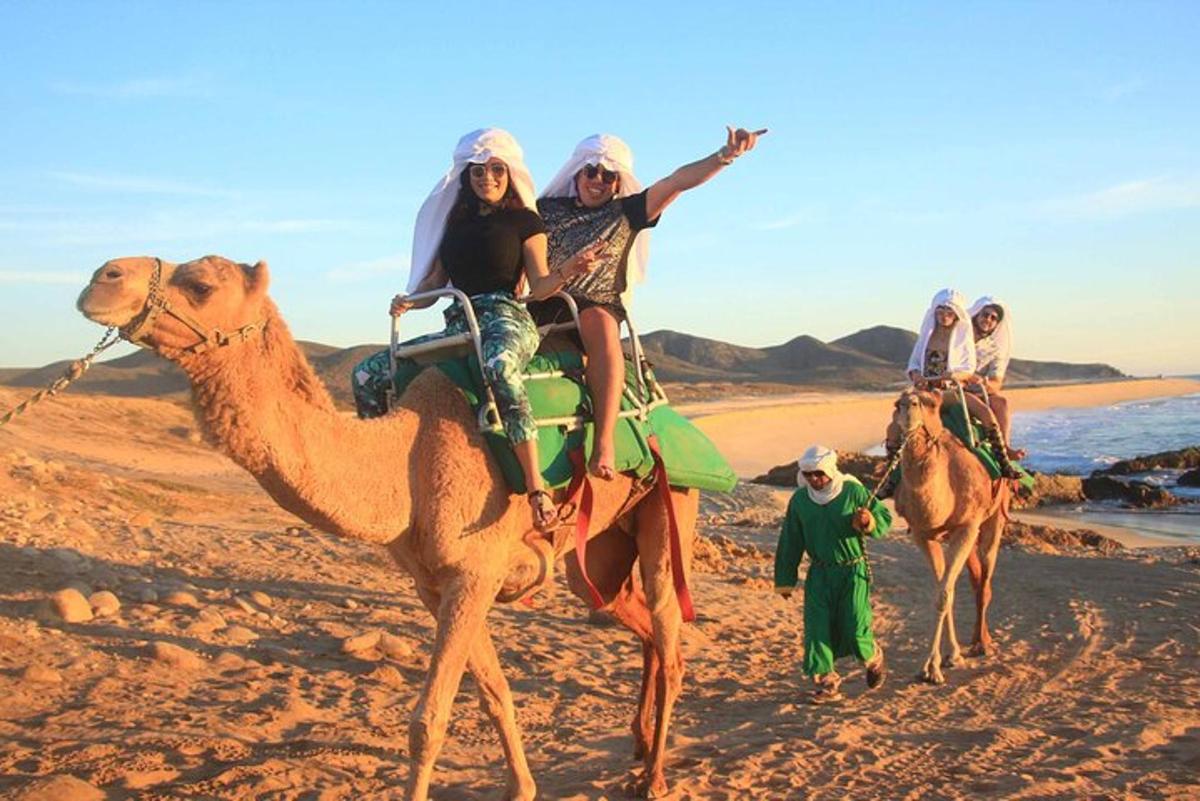 three people riding on a camel on the beach