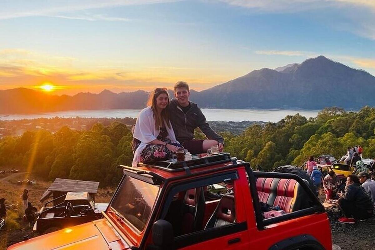 a man and a woman sitting on top of a jeep
