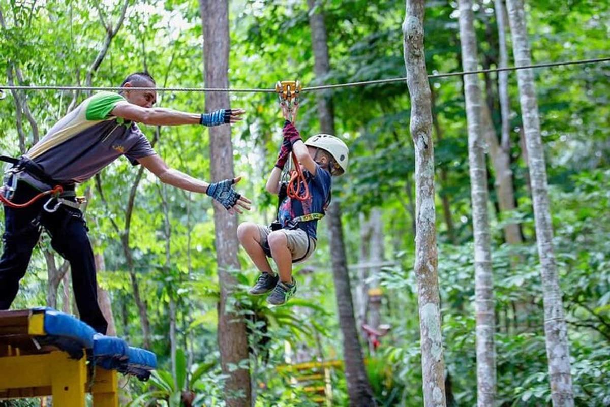 two people on a zip line in the jungle