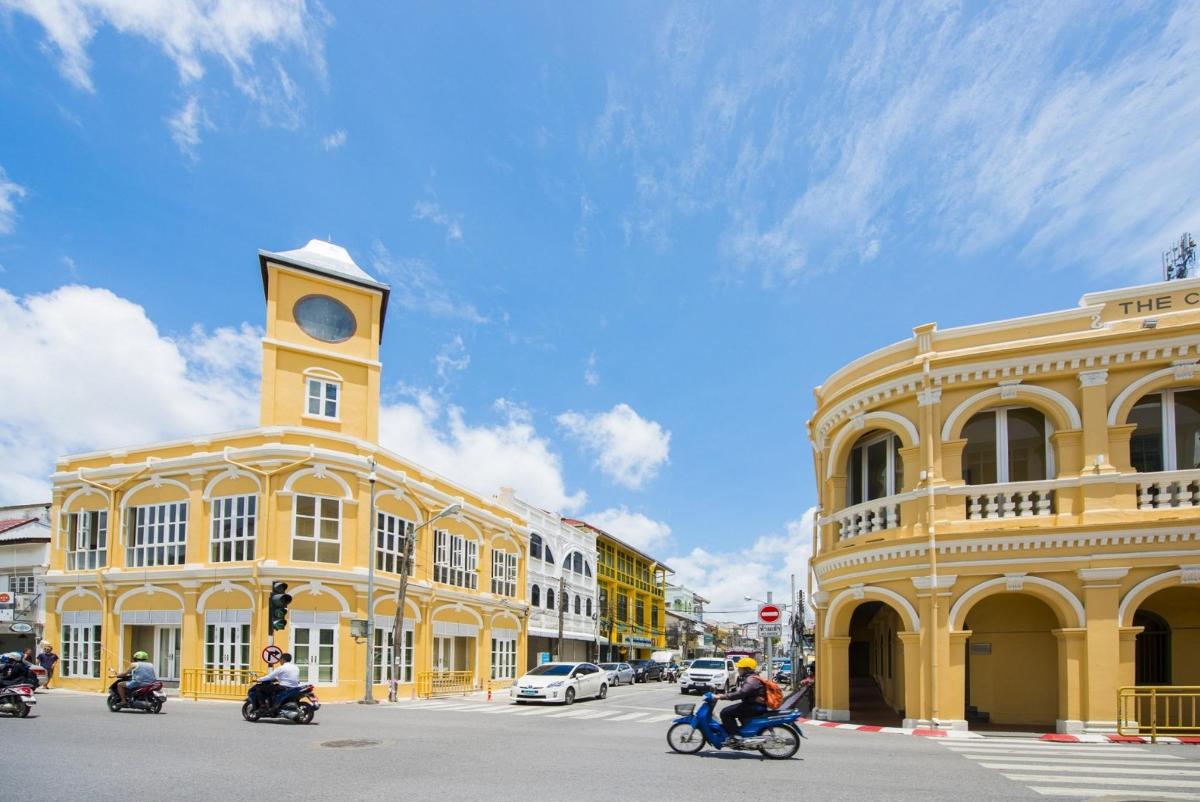 a yellow building with a clock tower on a street