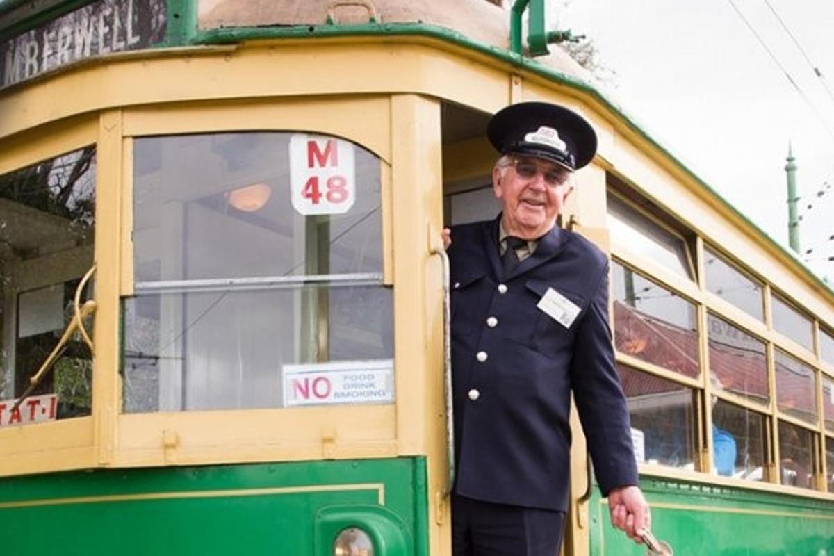 a man in uniform standing in front of a trolley