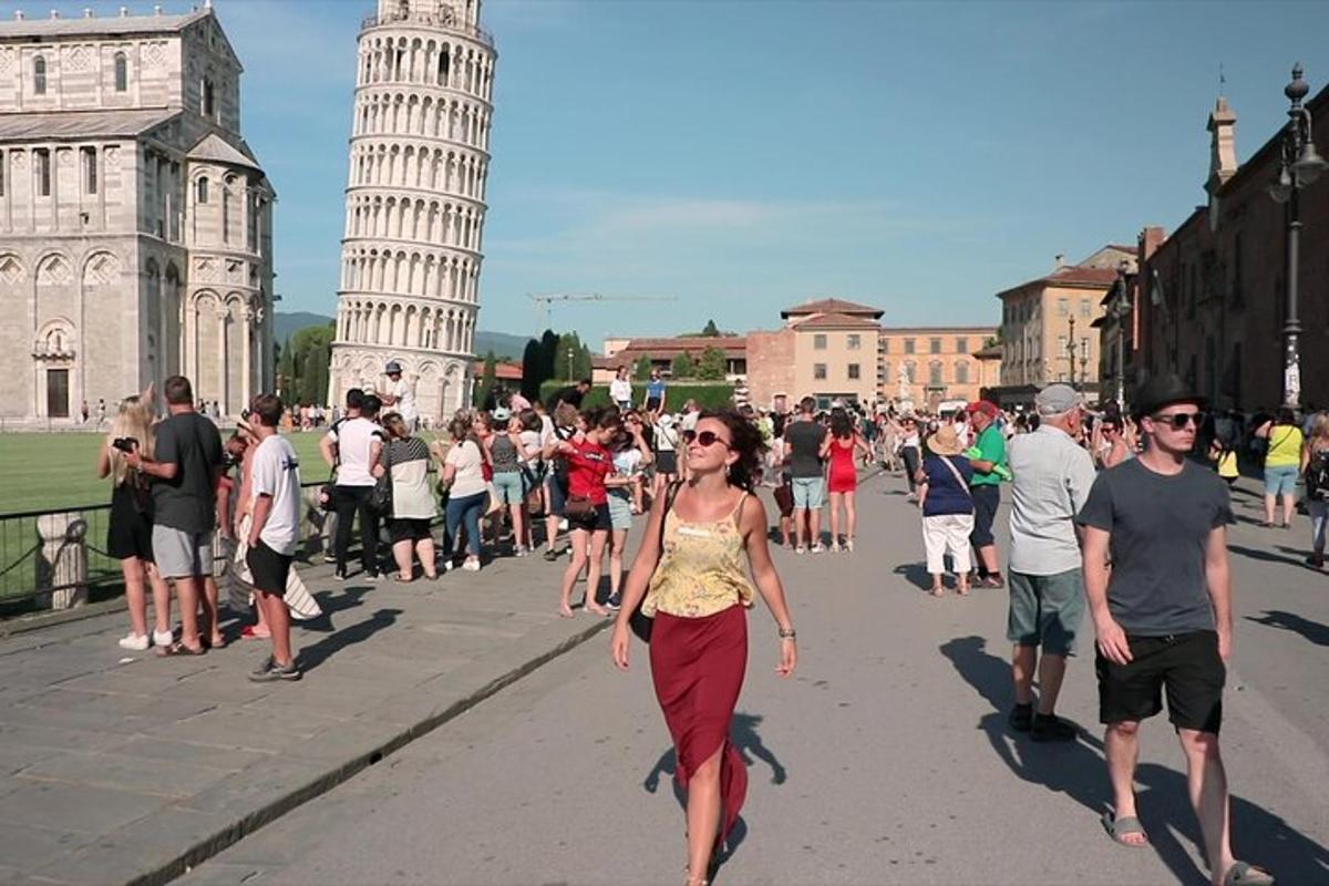 uma mulher caminhando pela rua em frente à torre inclinada