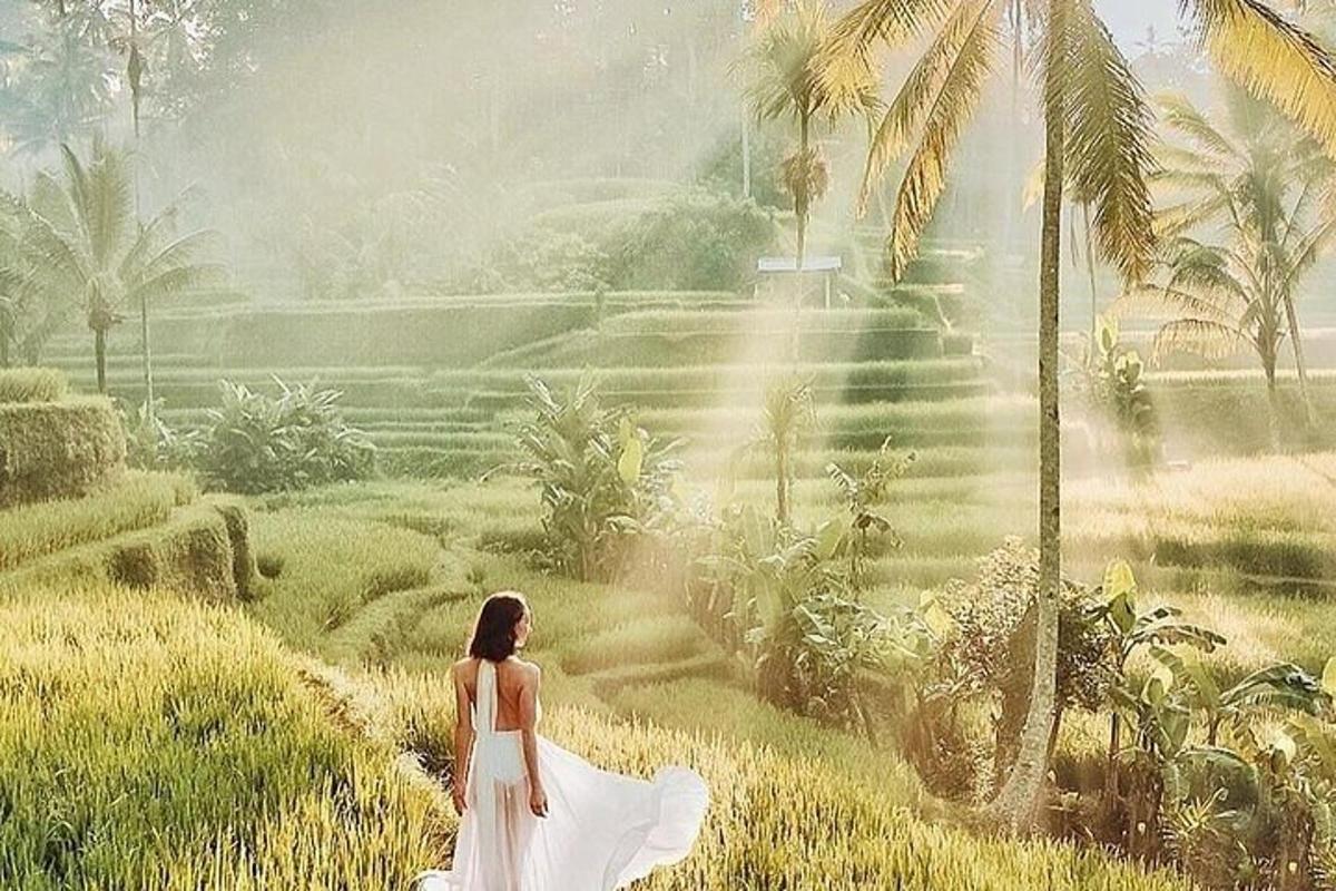 Una mujer con un vestido blanco caminando por un campo