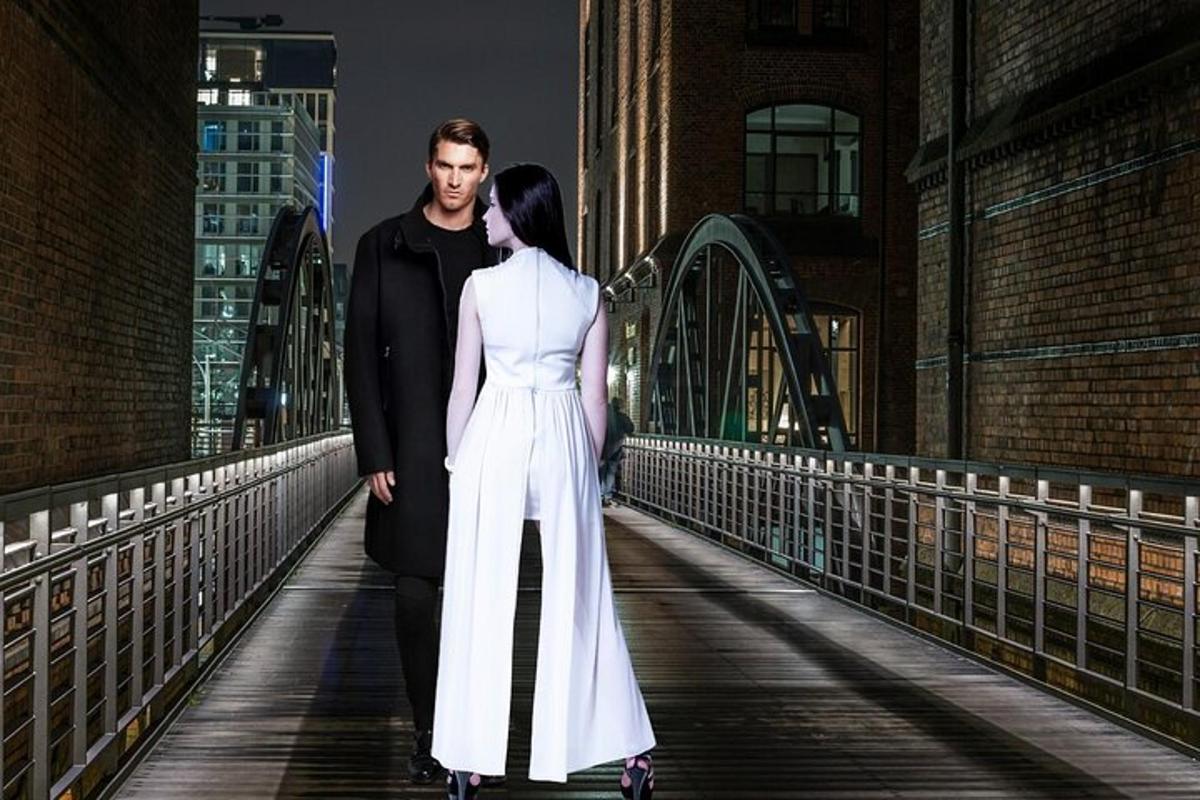 a man and a woman walking across a bridge