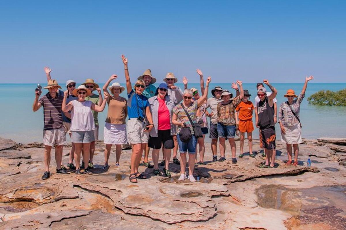 a group of people standing on rocks on the beach