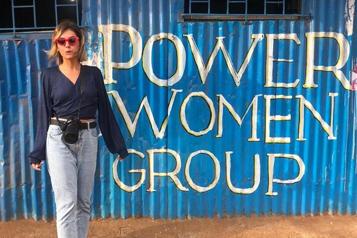 una donna è in piedi davanti a un muro blu