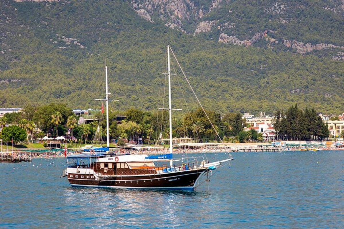 μια βάρκα που κάθεται στο νερό κοντά σε ένα βουνό