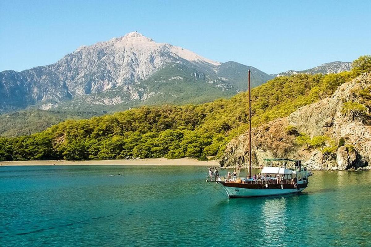 μια βάρκα στο νερό με ένα βουνό στο φόντο