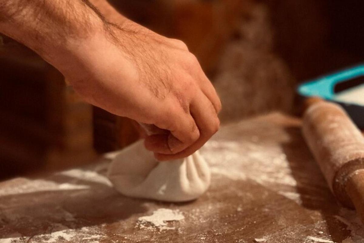 uma mão está mexendo em um objeto branco sobre uma mesa