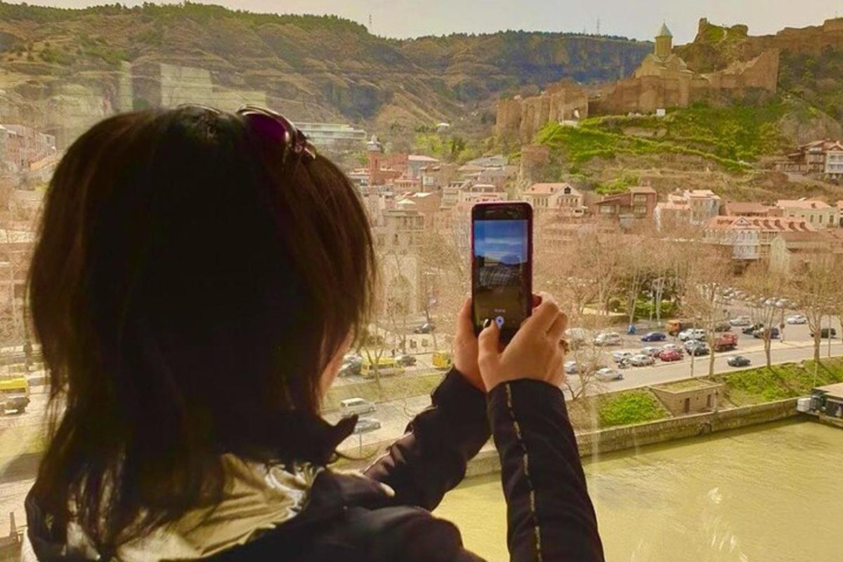 una dona fent una foto d'una ciutat amb el seu telèfon mòbil