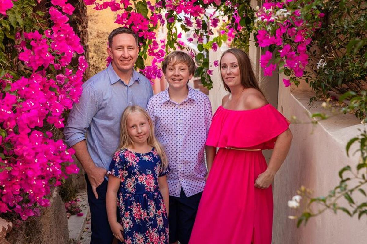 en familie som poserer for et bilde foran blomster