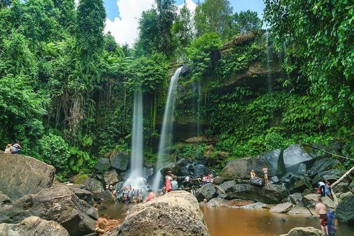 un gruppo di persone in un fiume con una cascata