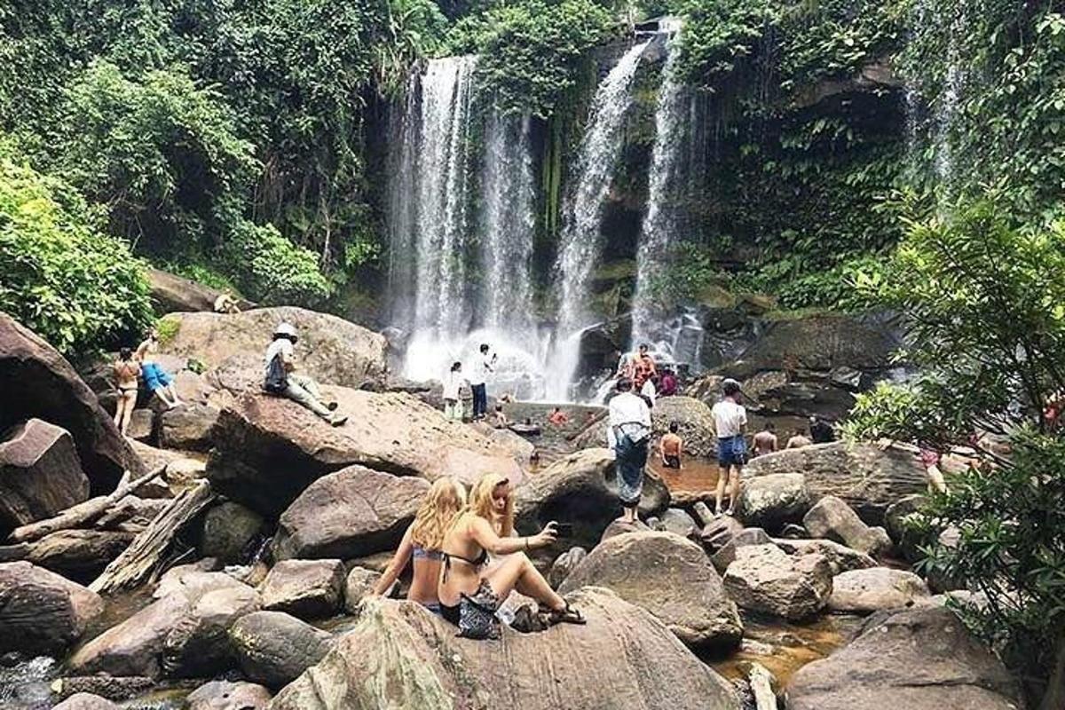 persone sedute sulle rocce di fronte a una cascata
