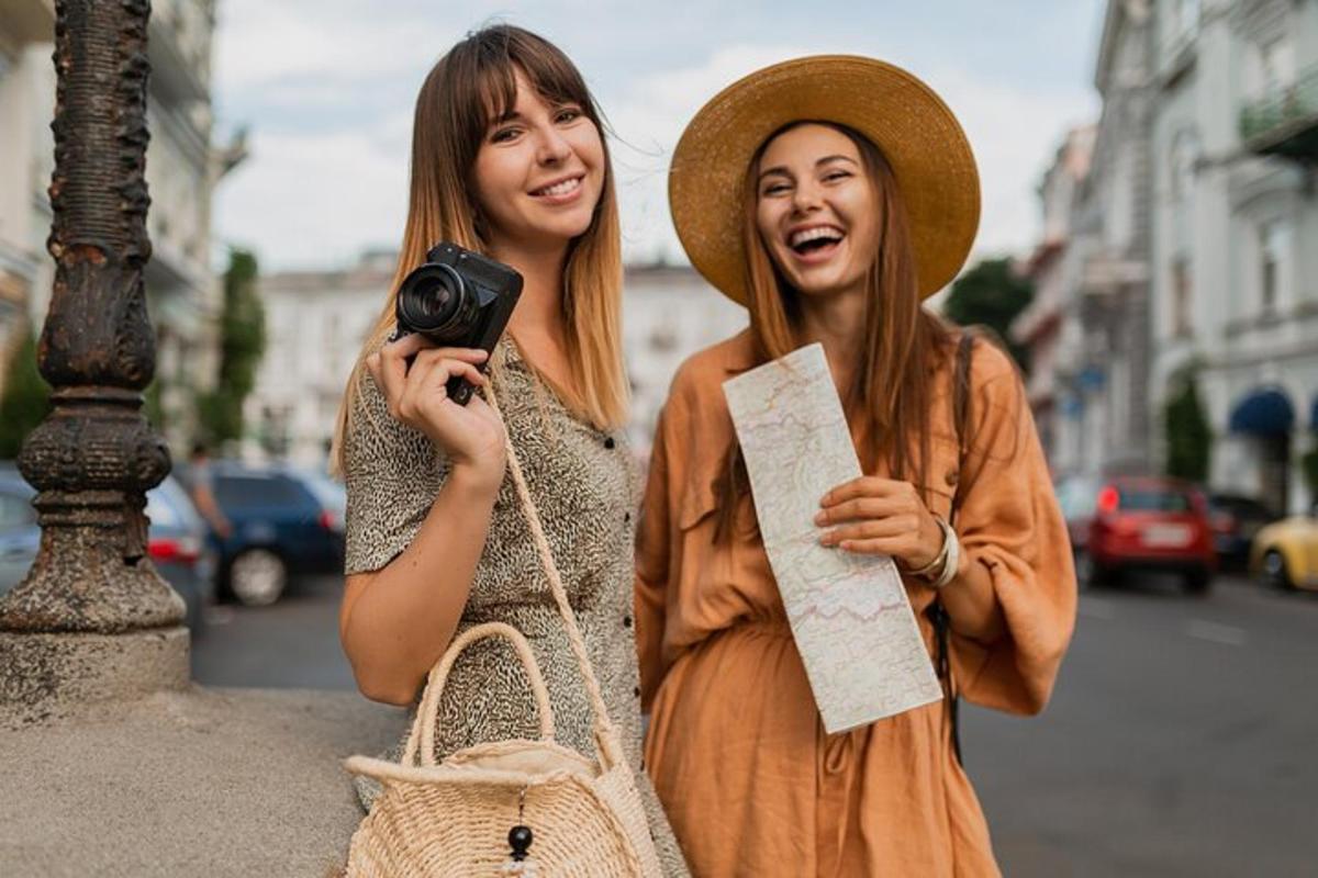 due donne camminano per strada tenendo in mano una macchina fotografica
