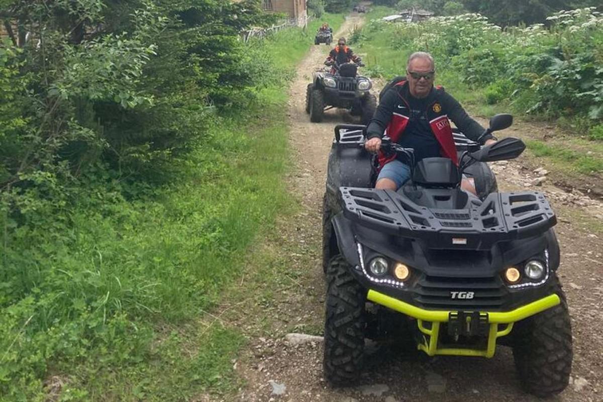 a man riding on a four wheeler on a dirt road