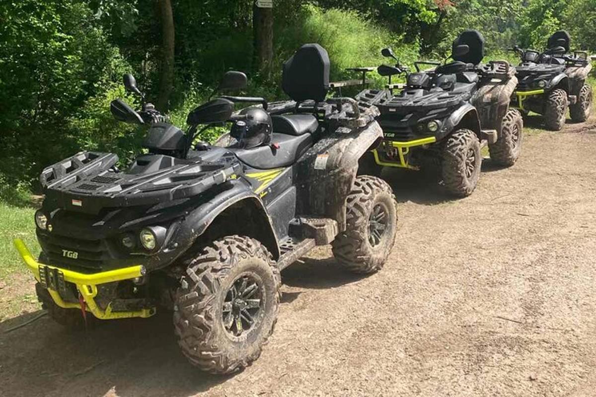 a row of four atvs parked on a dirt road
