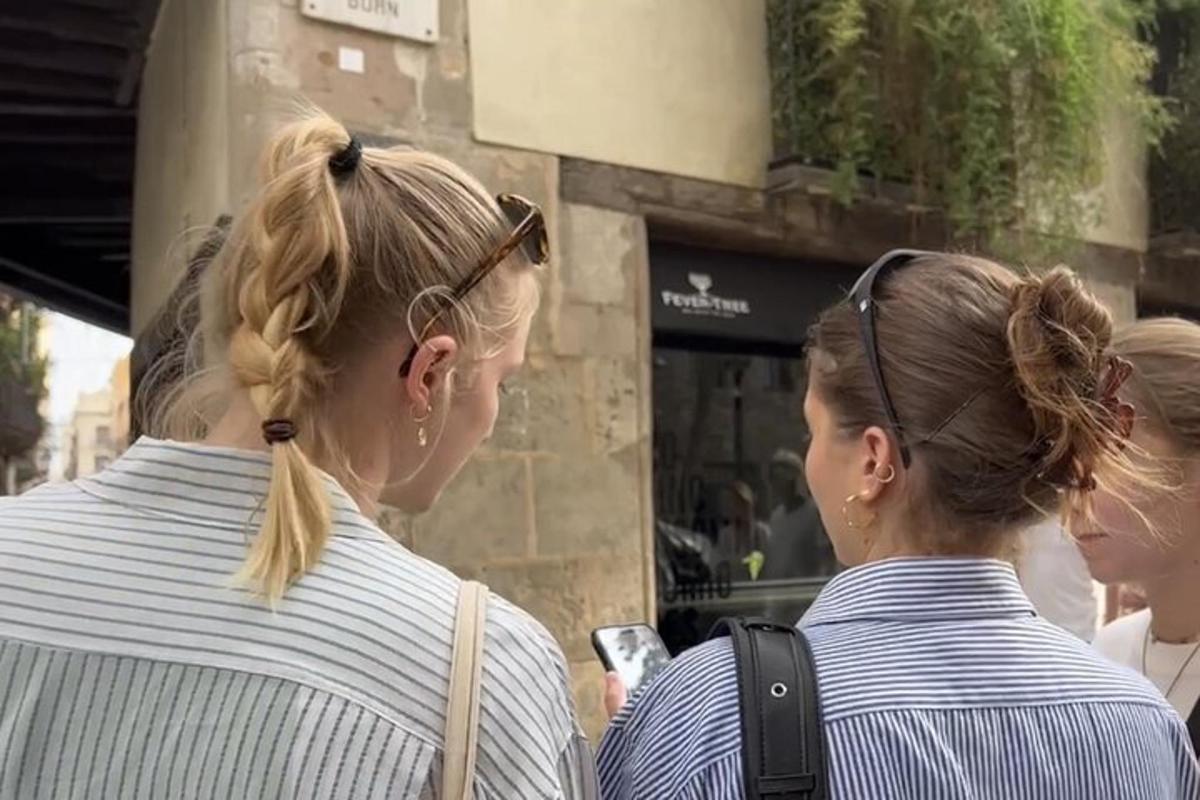 Dvě ženy se dívají do svého mobilního telefonu