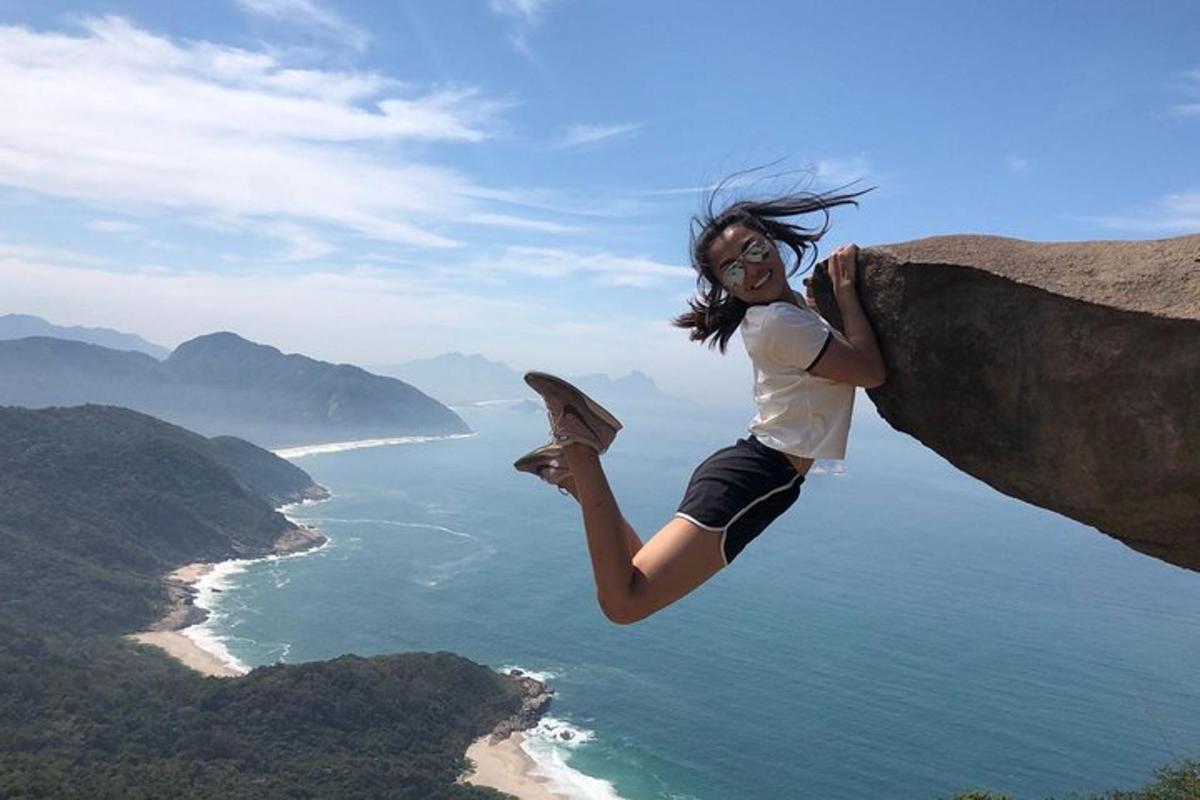 바다를 바라보는 바위에 매달려 있는 여자