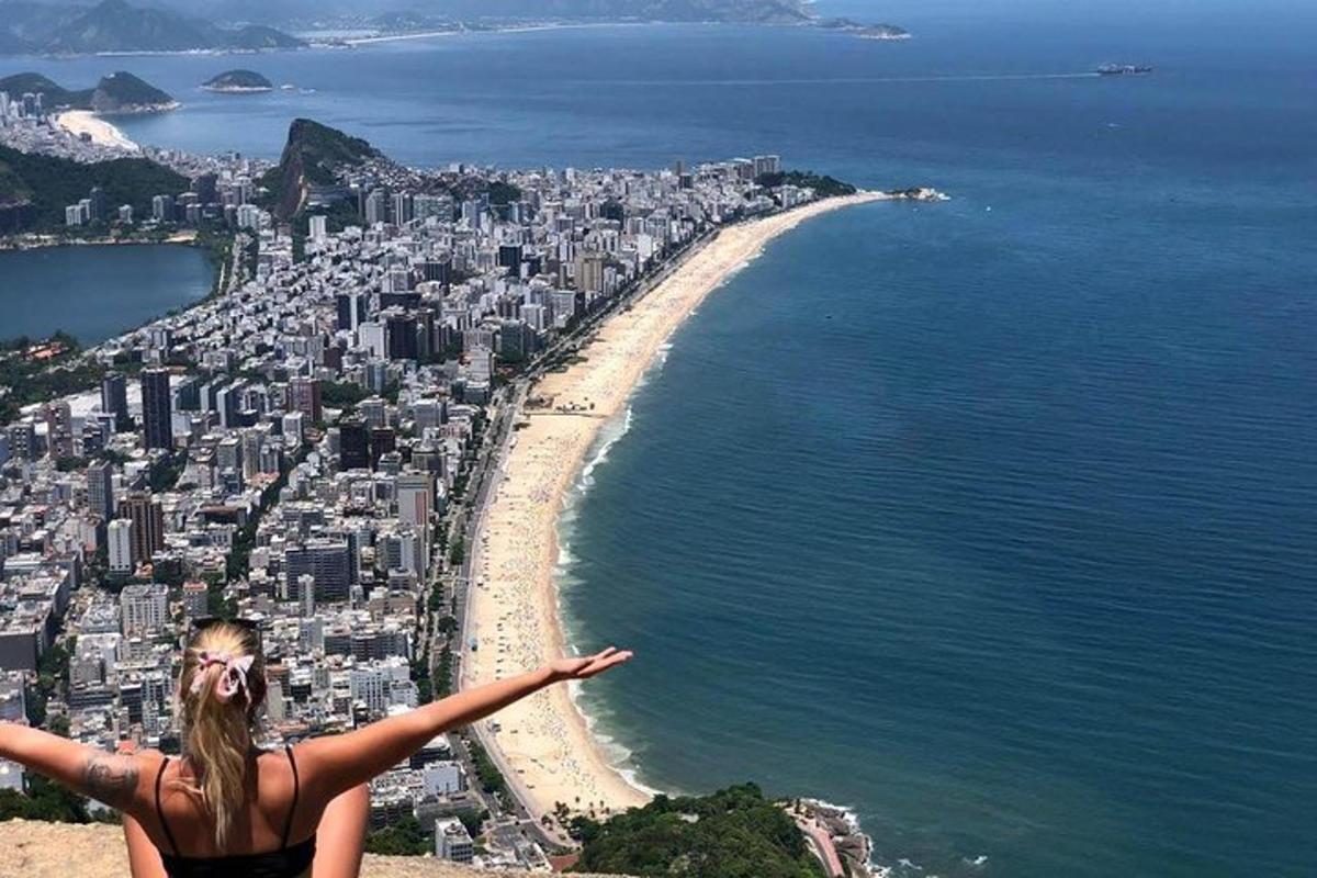 uma mulher em pé no topo de uma colina com vista para uma cidade