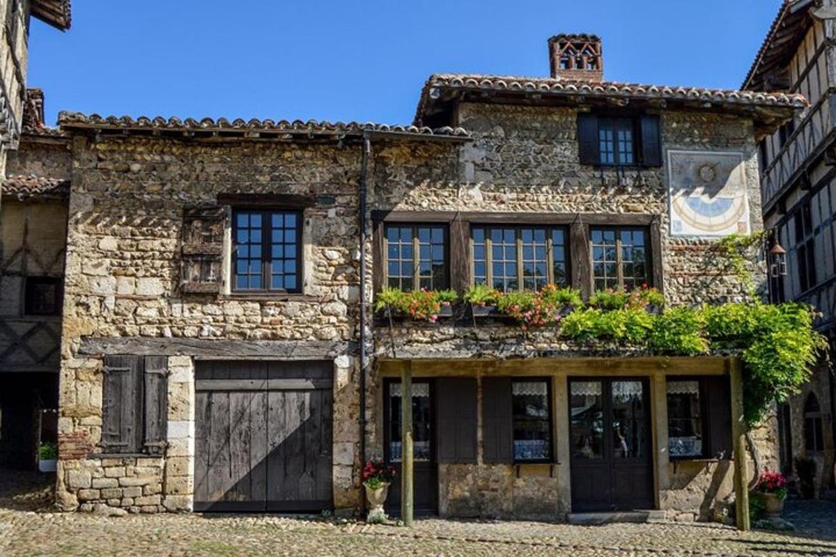 un antic edifici de pedra amb garatge i plantes