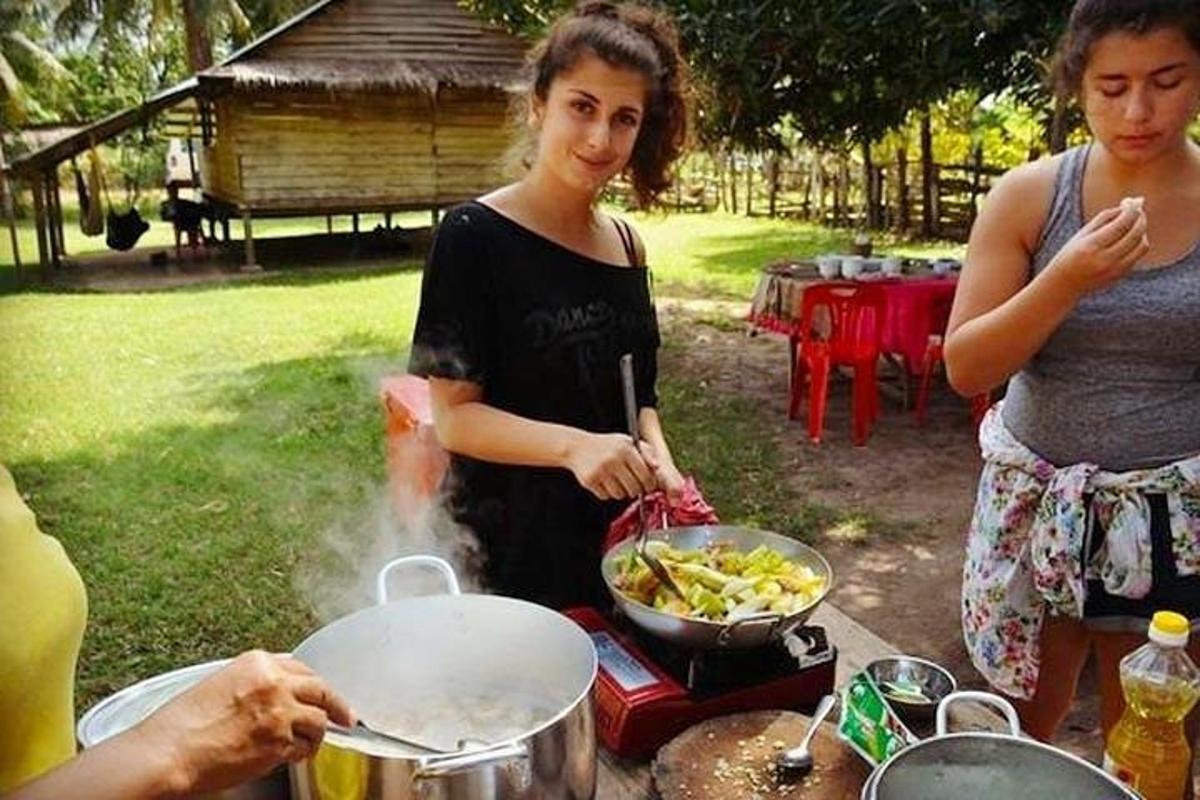 μια γυναίκα μαγειρεύει φαγητό σε τηγάνι στη σχάρα