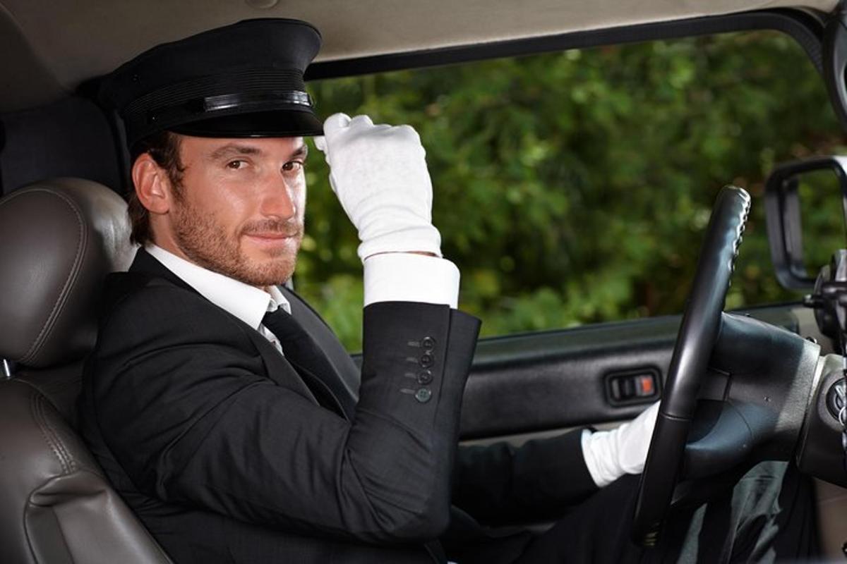Un hombre con traje y sombrero en un coche.