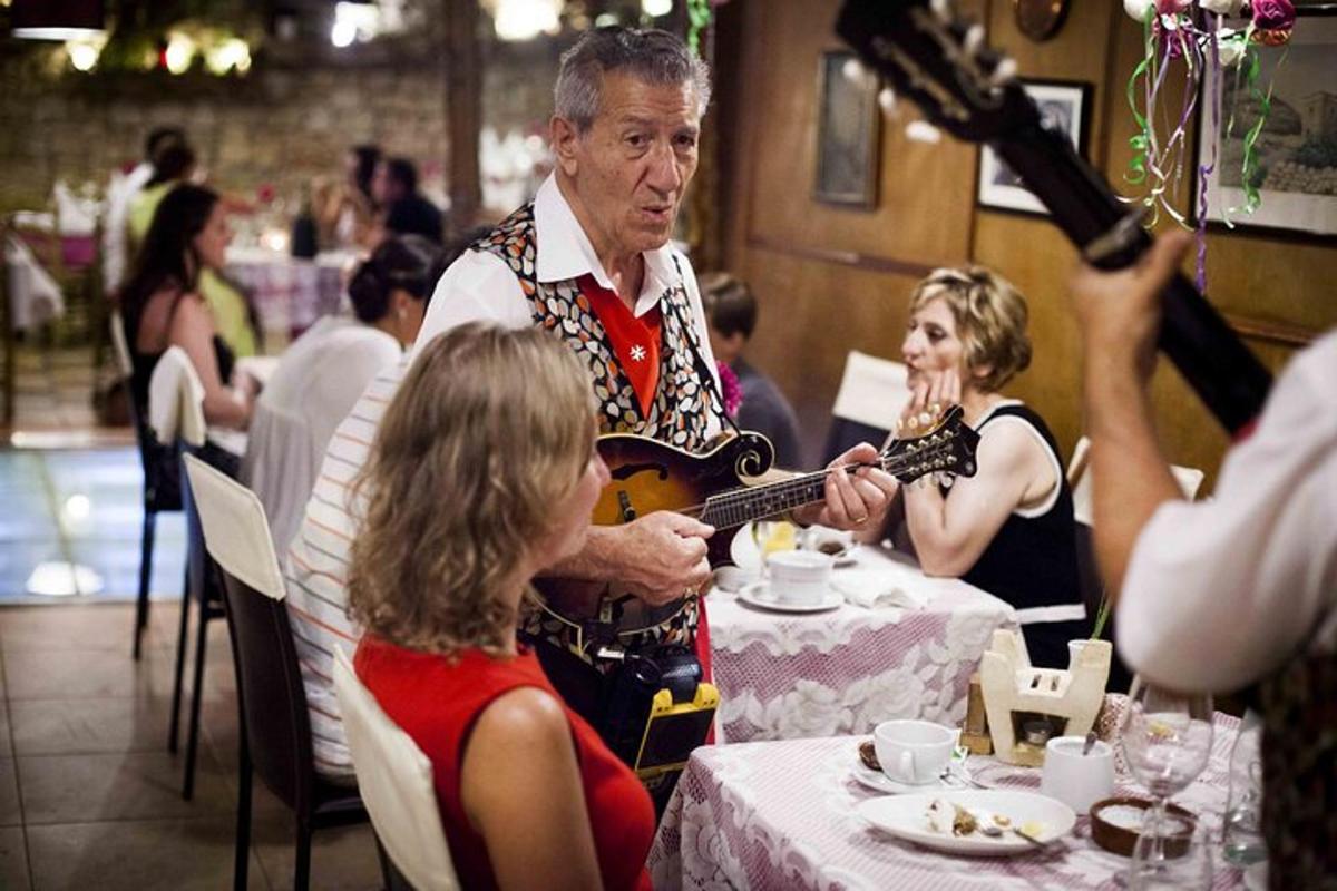 a man playing a guitar for a girl at a table