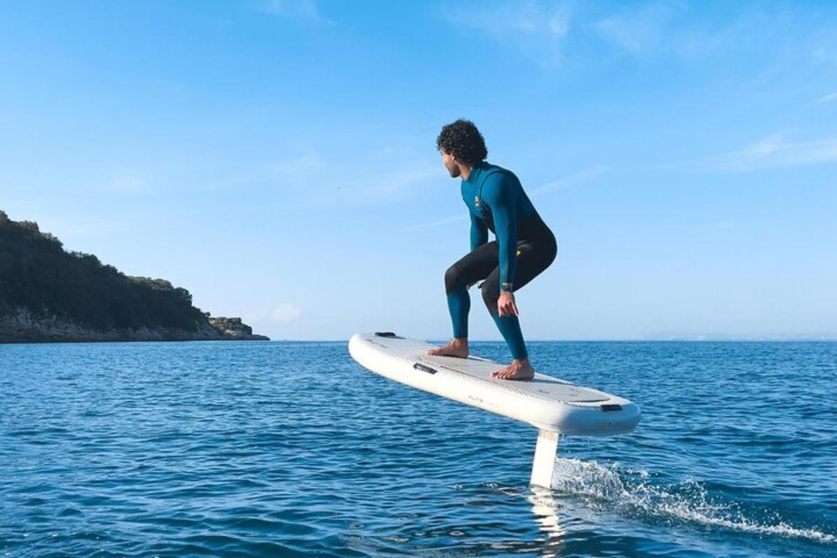 一名男子站在水中的冲浪板上