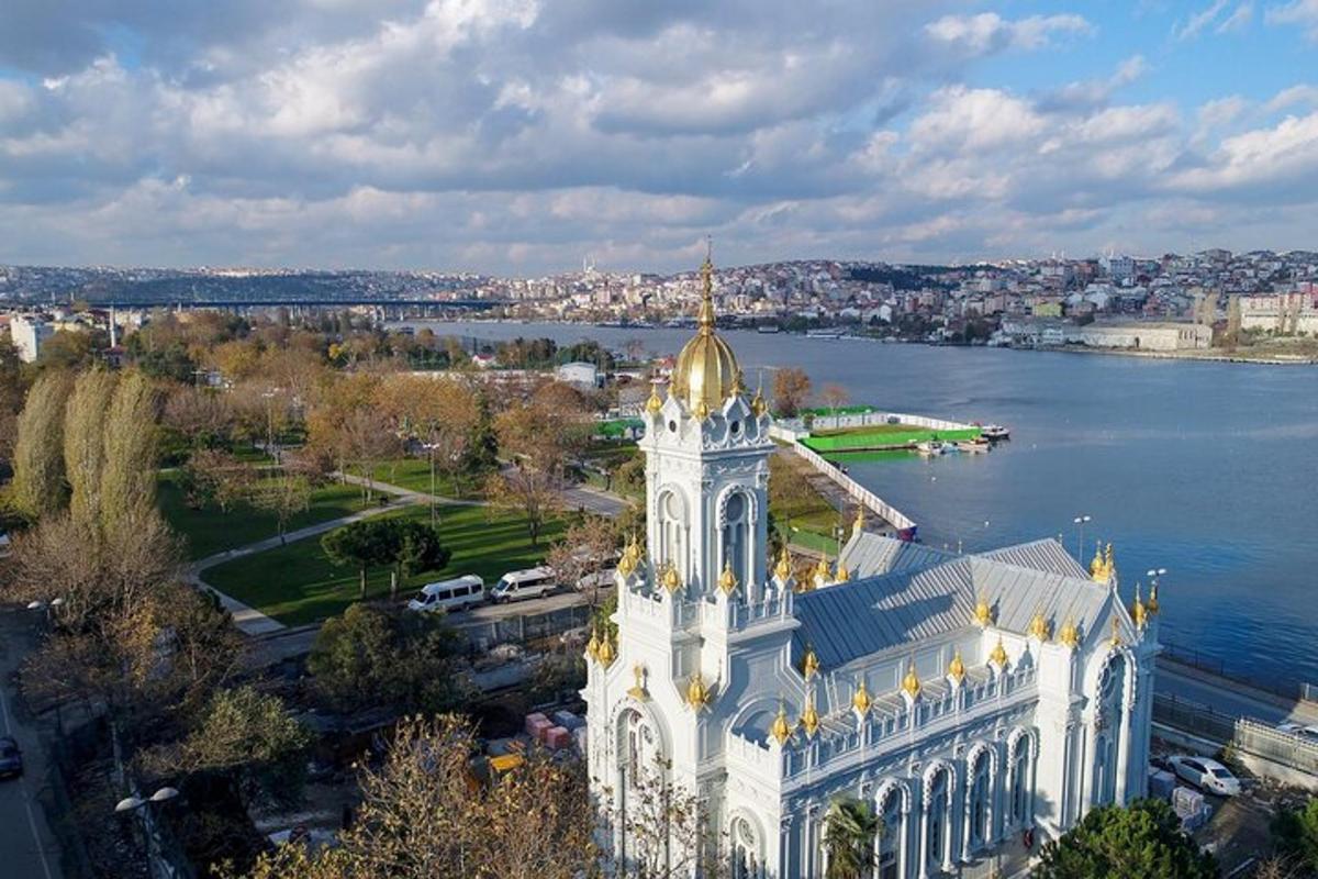 velká bílá budova se zlatou střechou vedle vody